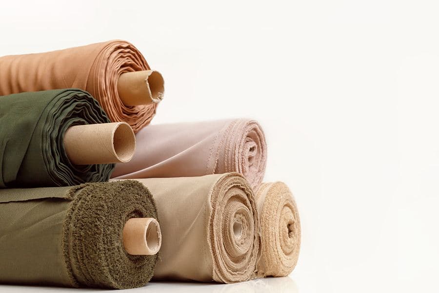 Rolls of flame-retardant fabric yardage in neutral tones
